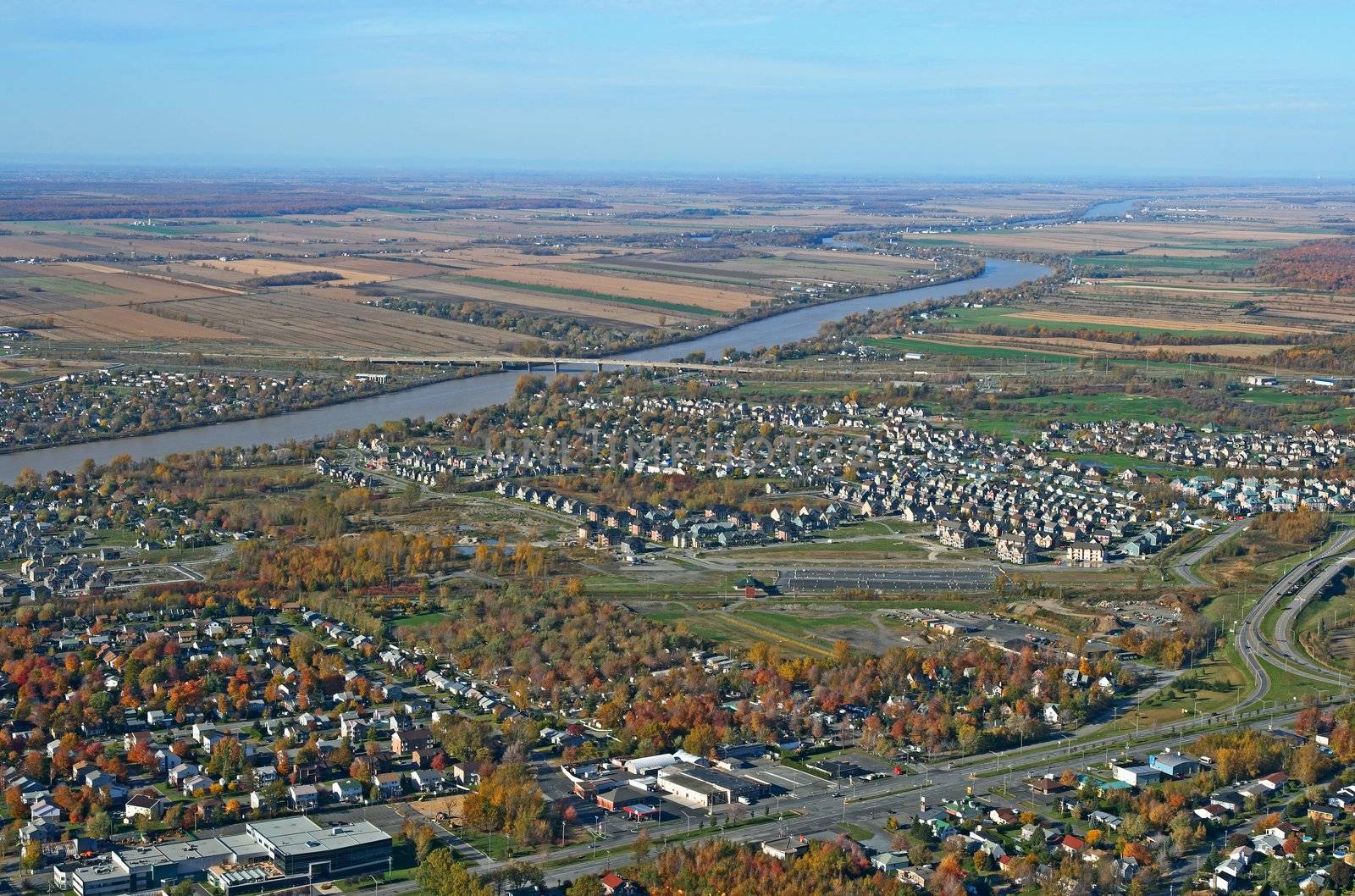 Aerial view of residential area and river in bright colors of autumn.