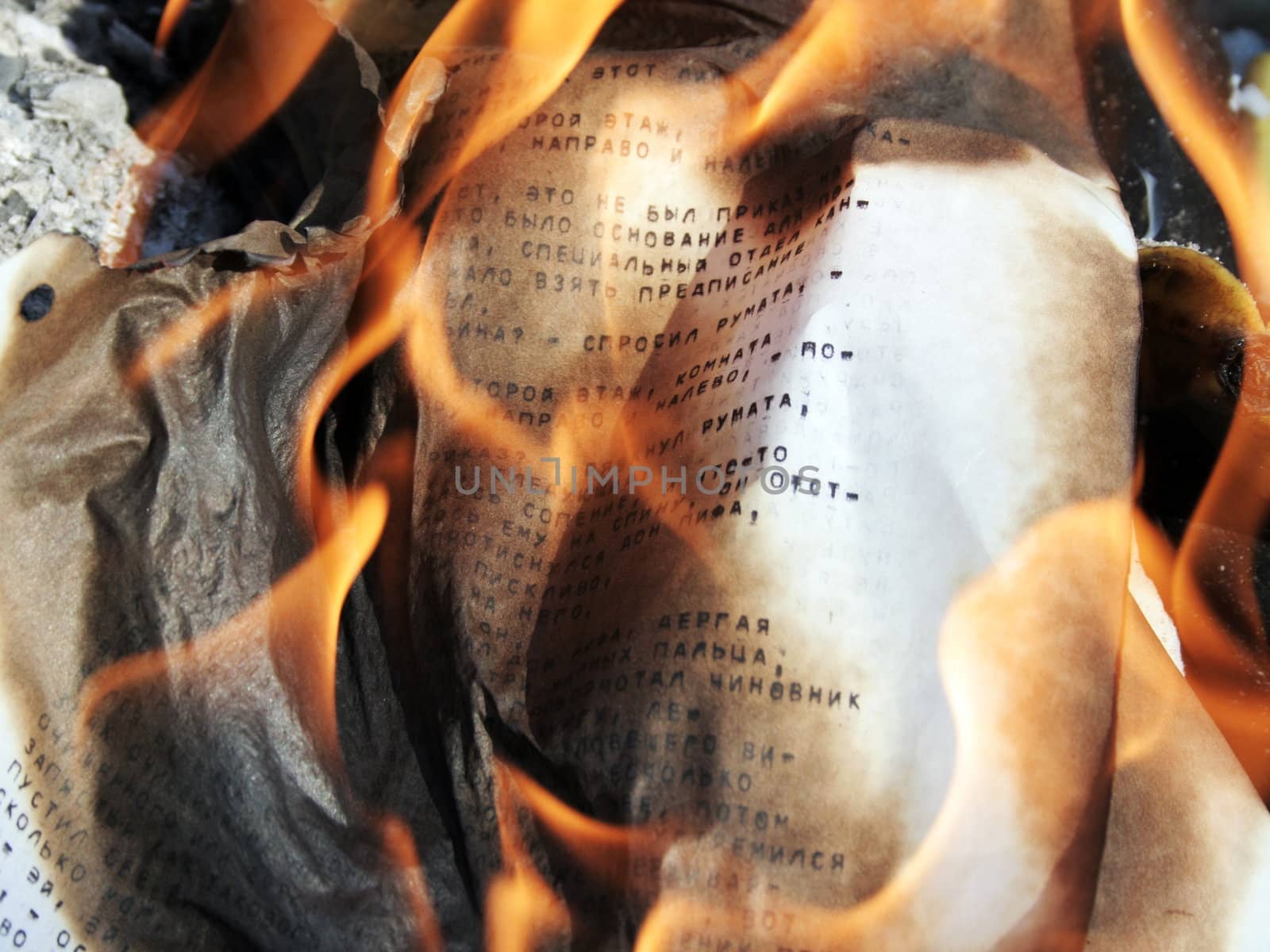Burning paper with typed russian letters 