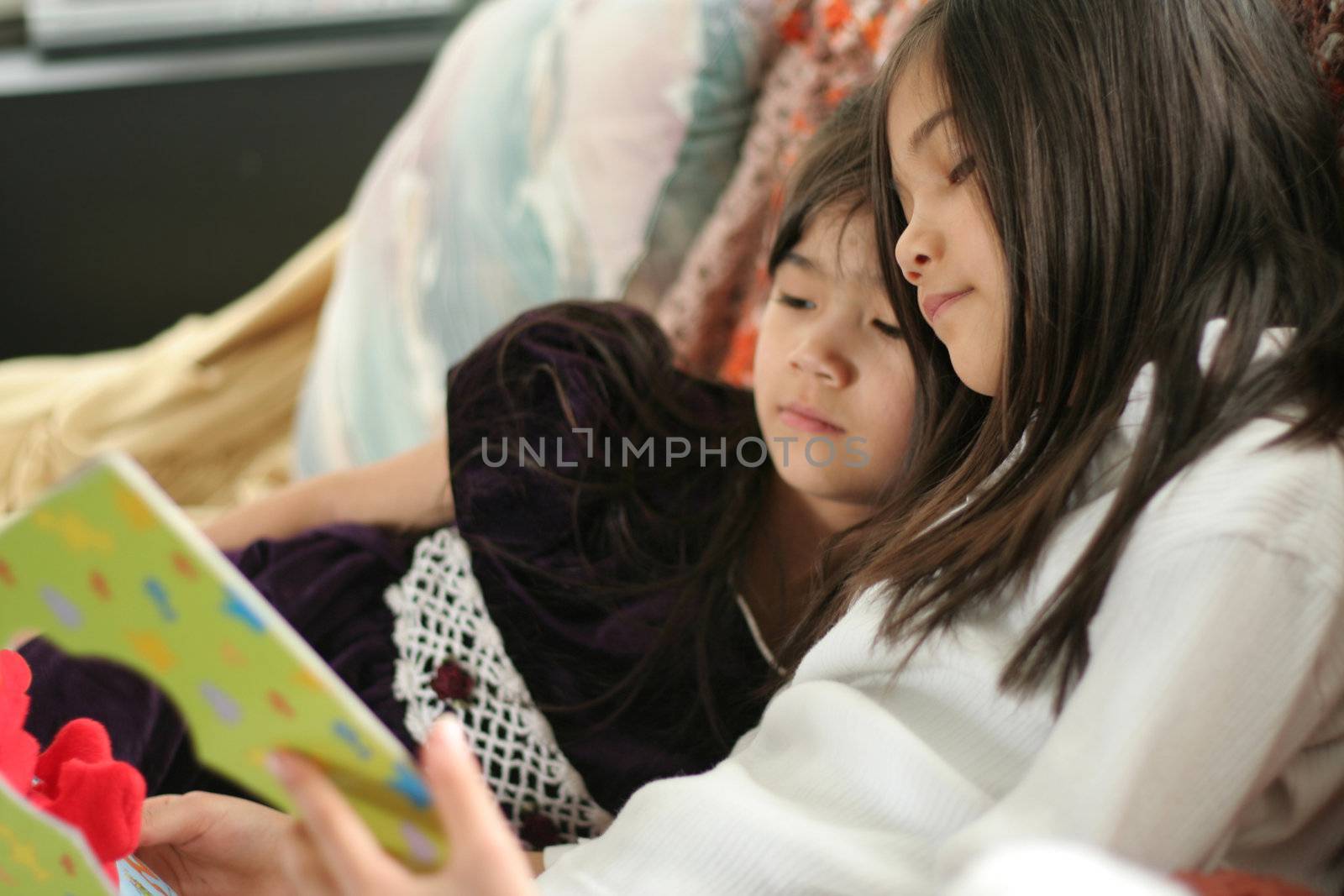 Two girls reading a book by jarenwicklund