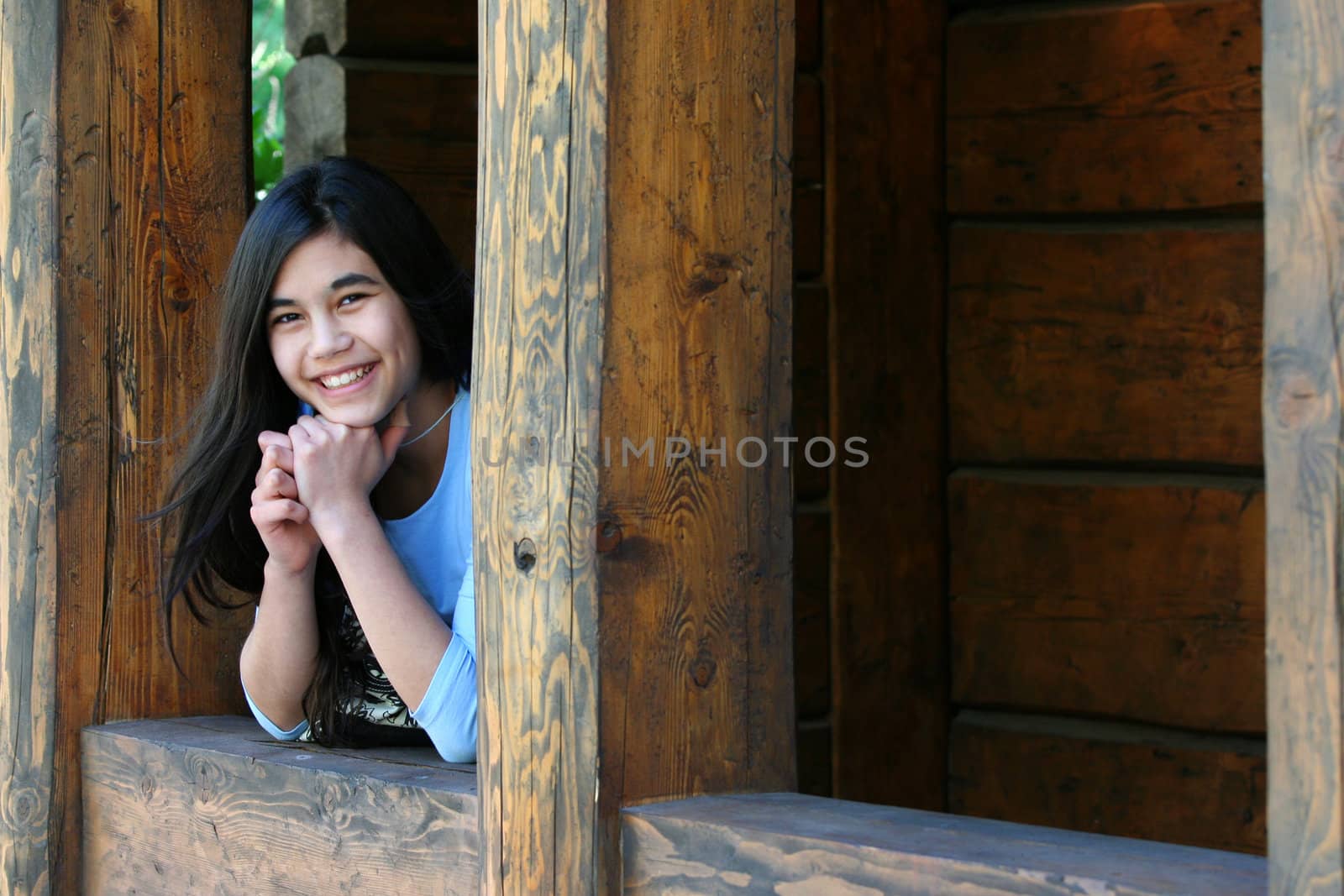 Beautiful young teen girl relaxing on porch, part asian, scandinavian background