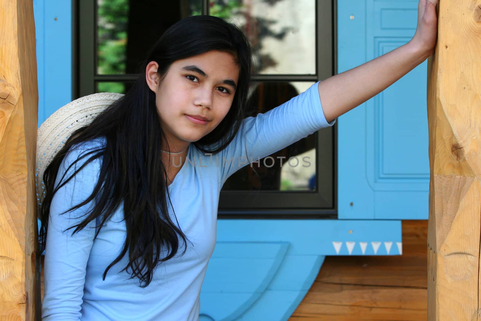 Beautiful young teen girl relaxing on porch, part asian, scandinavian background