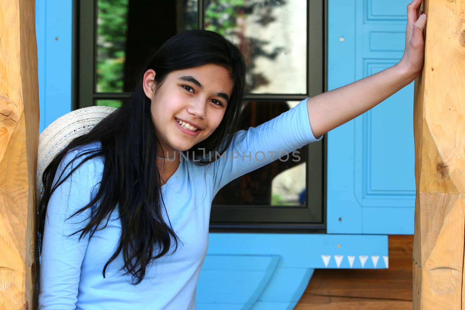 Beautiful young teen girl relaxing on porch, part asian, scandinavian background