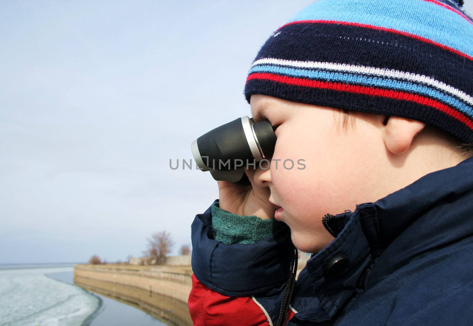 Little boy with binoculars at a sea