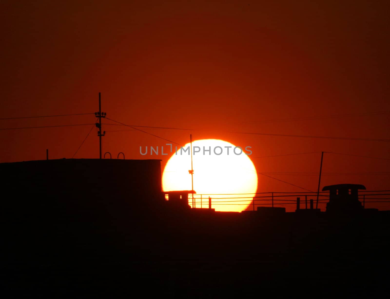 Darkly-purple sunset of a sun above the roofs of houses 2