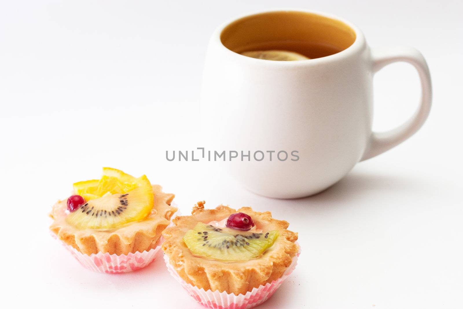 A couple of tartlets and a cup of tea with lemon