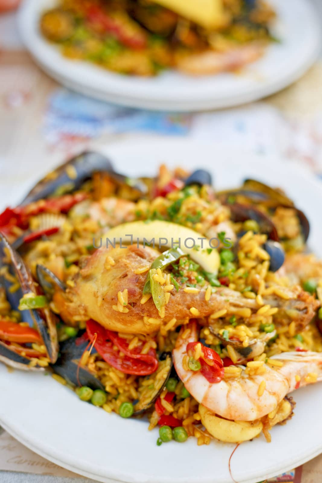 Beautiful and delicious paella in a white plate. Selective focus.
