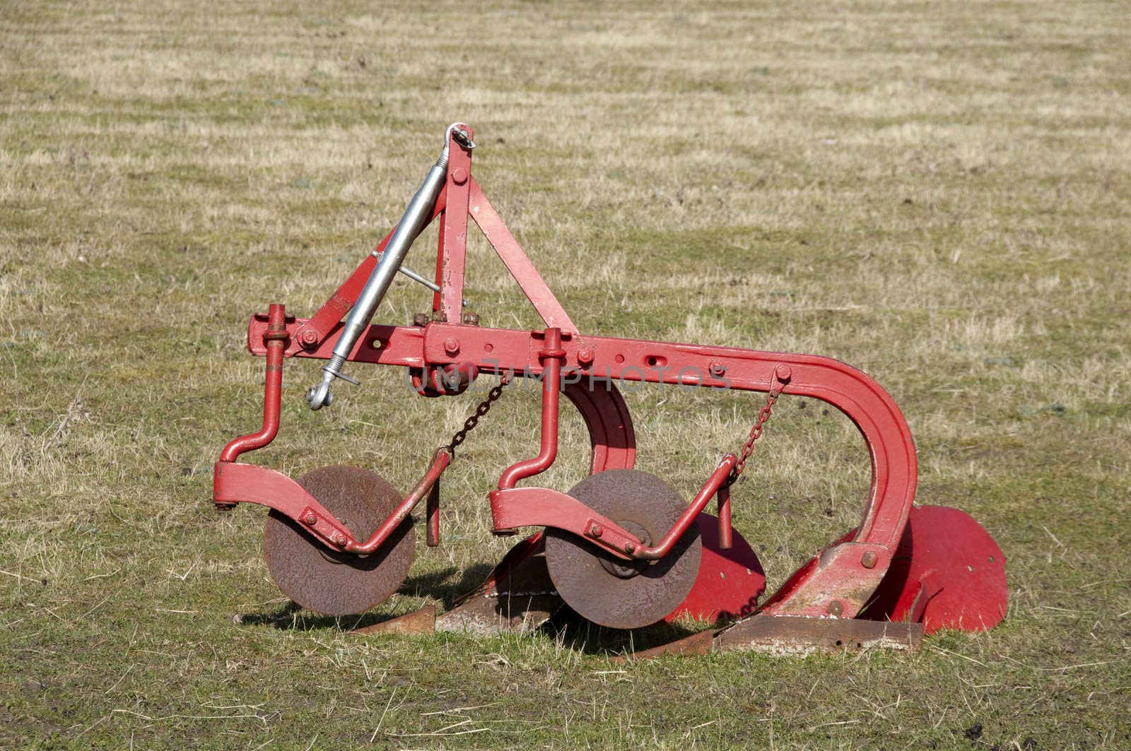An old plough in a field of grass
