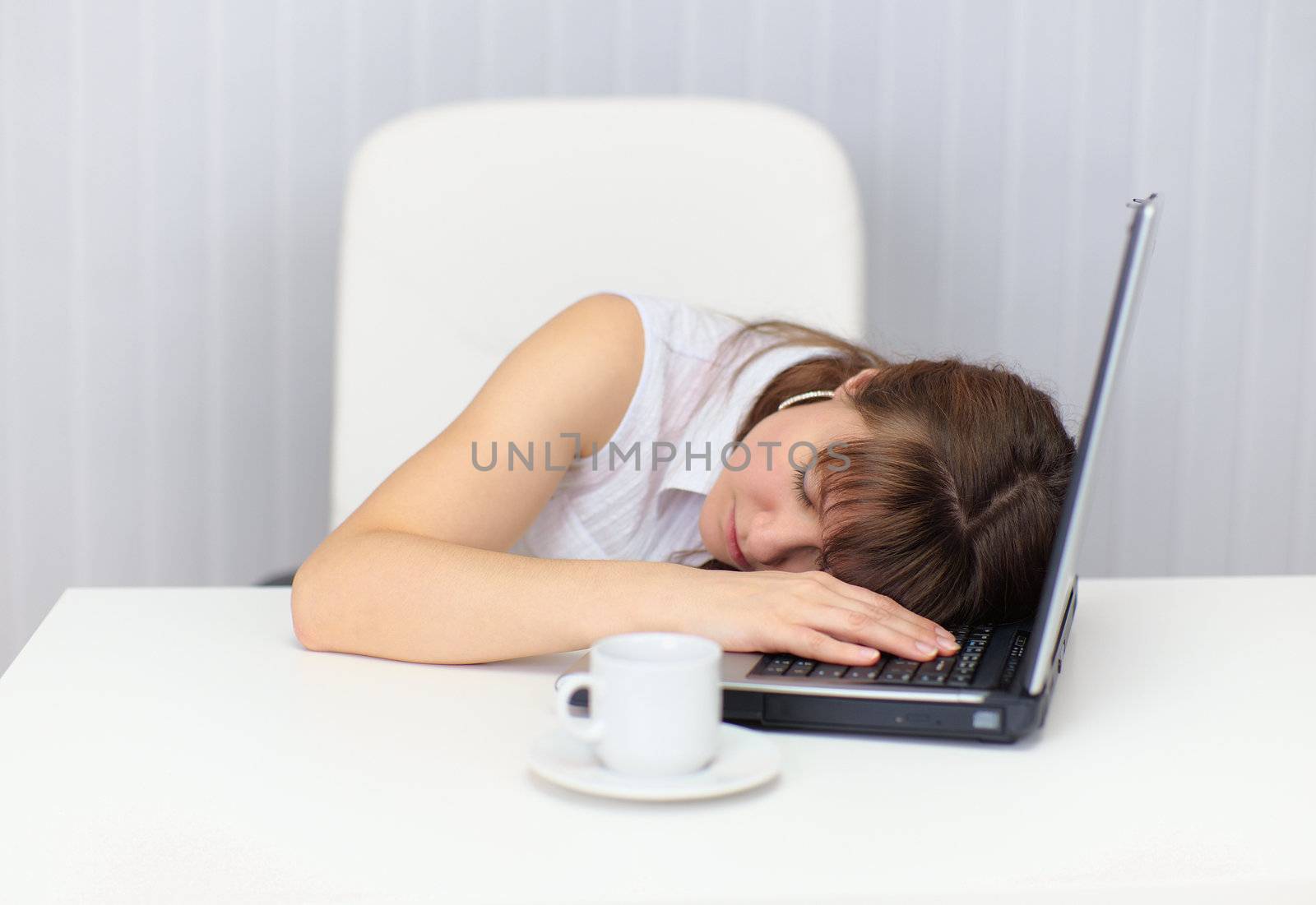 The woman was tired and fell asleep at the table with a laptop