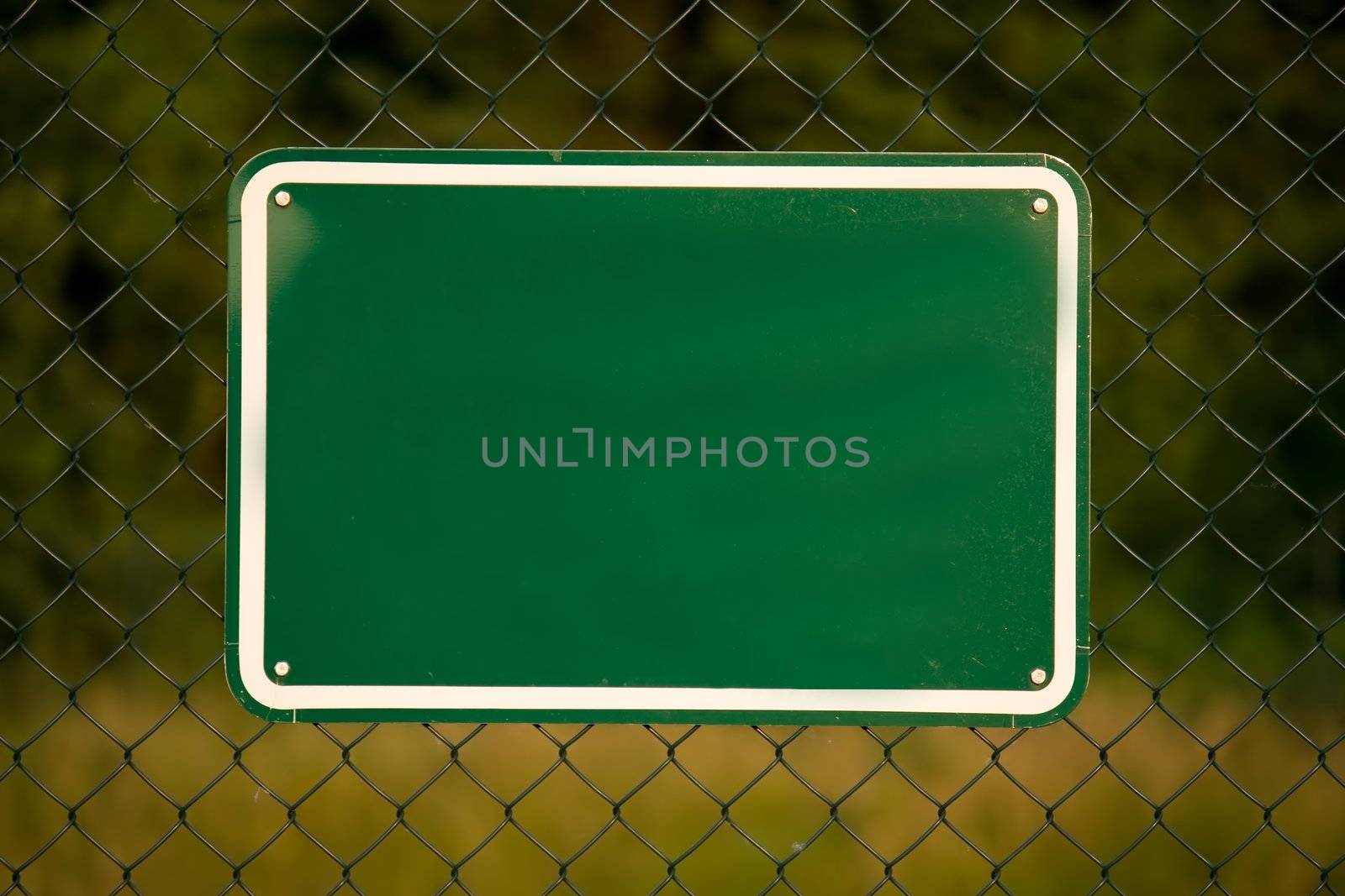 Fence with a blank green sign