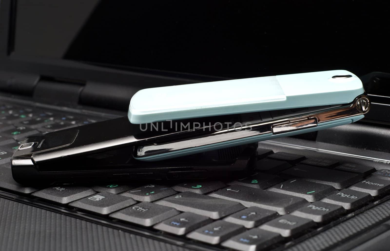 Two Cellular phones on a laptop