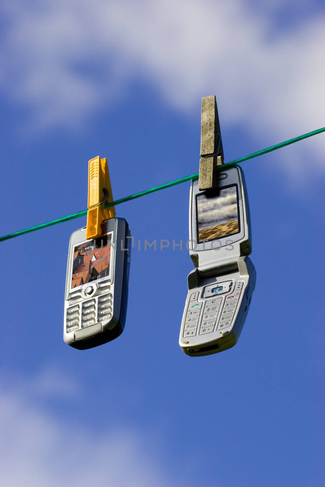 Two Cell Phones Drying on Clothesline / Network of wireless devices. Clipping path for displays included