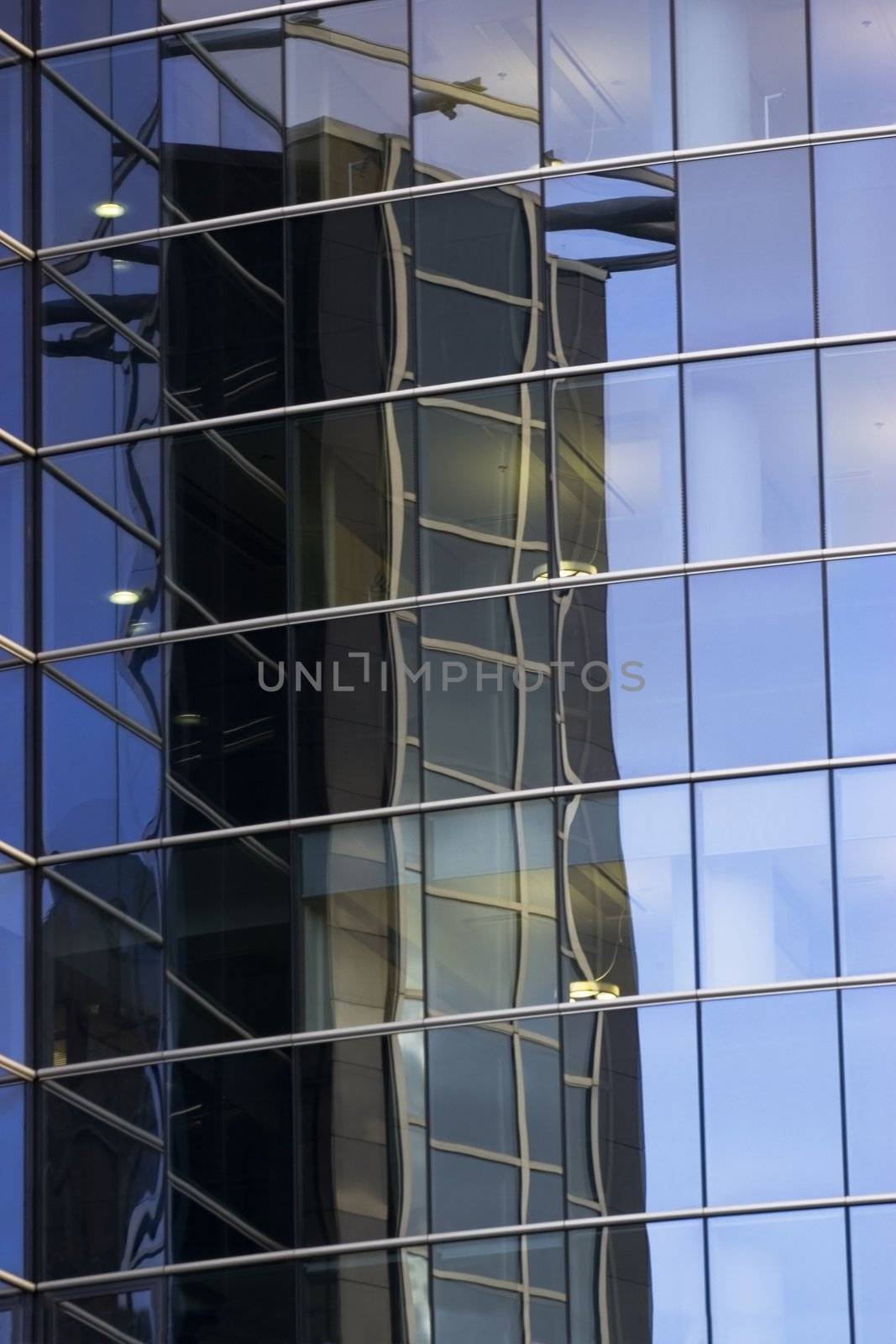 Corporate office building facade and reflection of other skyscraper in windows