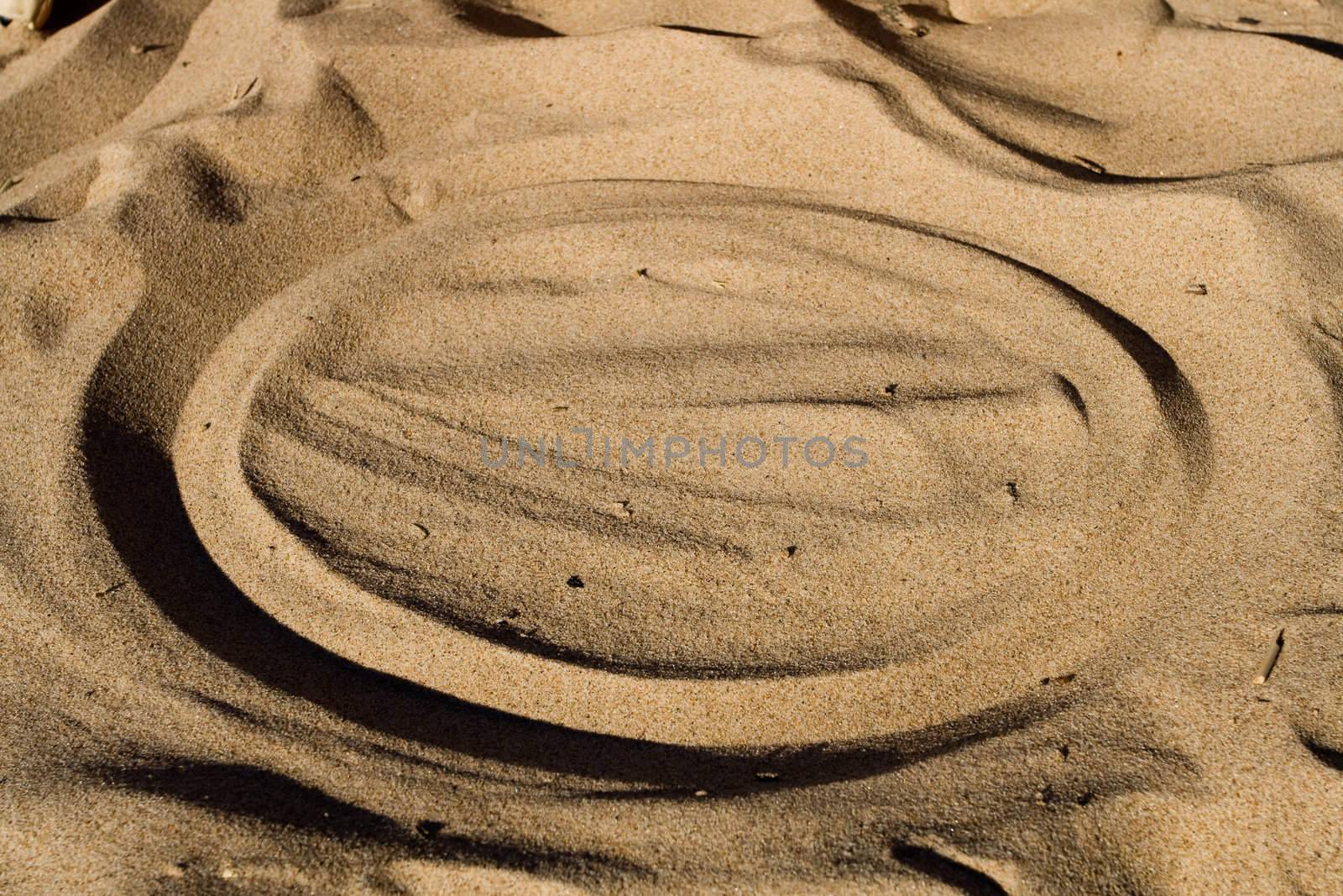 Cirlce in beige beach sand. Summer vacation background with lots of copy space.
