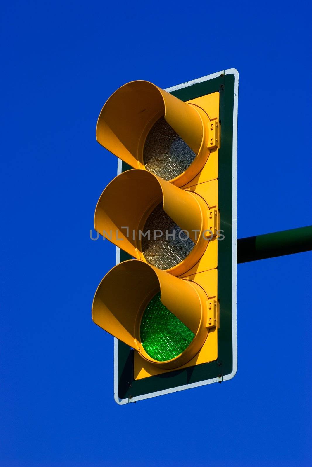Green traffic light on blue sky