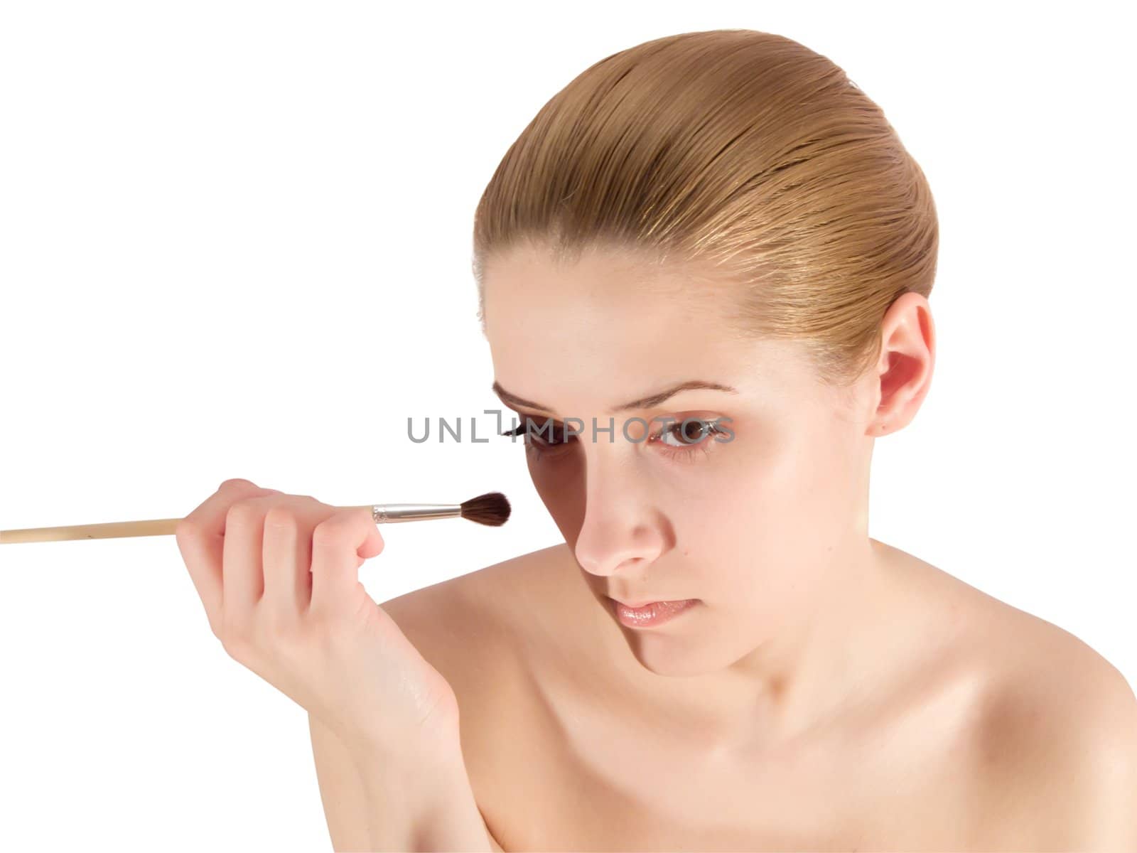 young woman putting make up on her face. Isolated