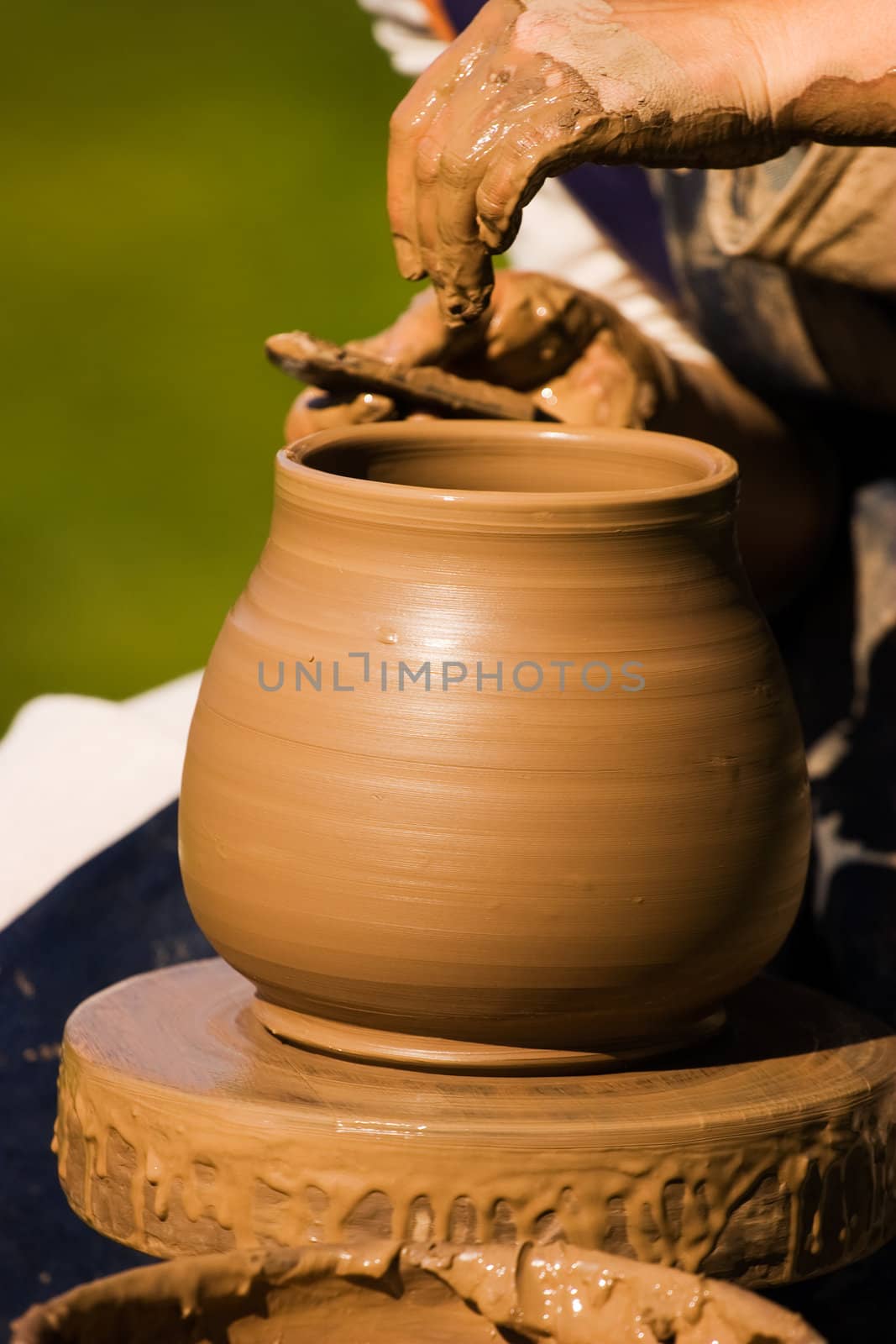 Potters hands creating a traditional clay vase on the turning wheel