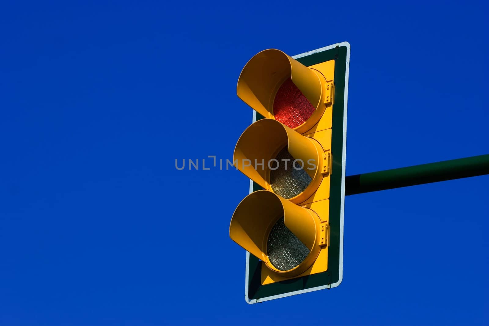 Red traffic light on blue sky