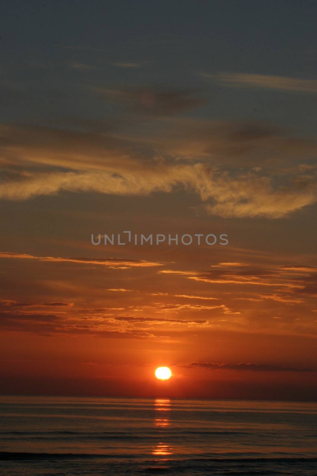 Sunset skies with clouds over sea