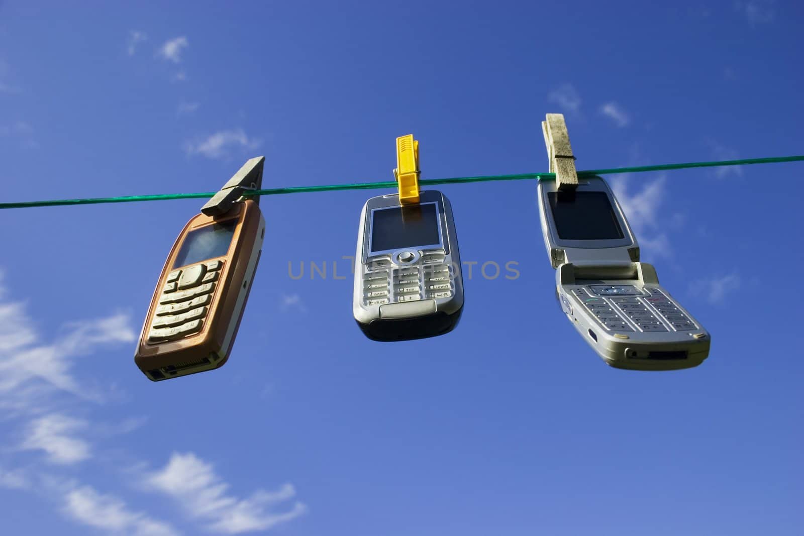 Three Cell Phones Drying on Clothesline / Network of wireless devices