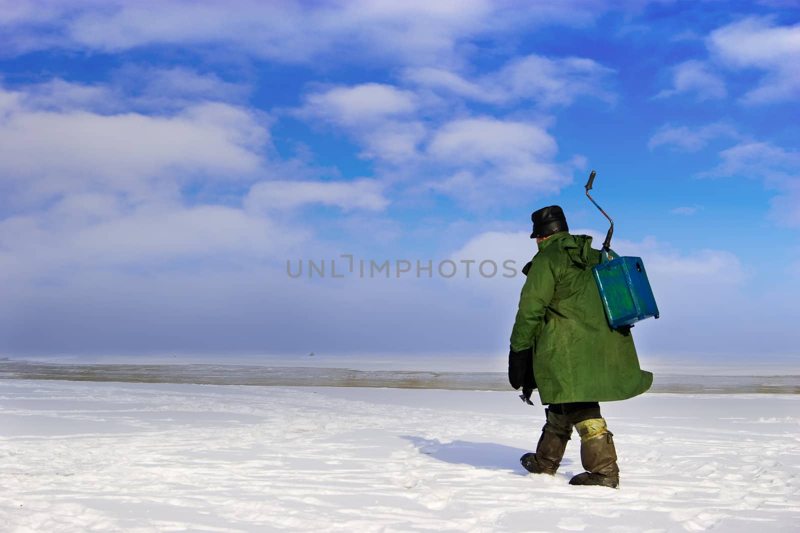 Ice Fisherman going away. Ice fishing - very popular winter hobby in Estonia, Latvia, Lithuania, Russia etc.