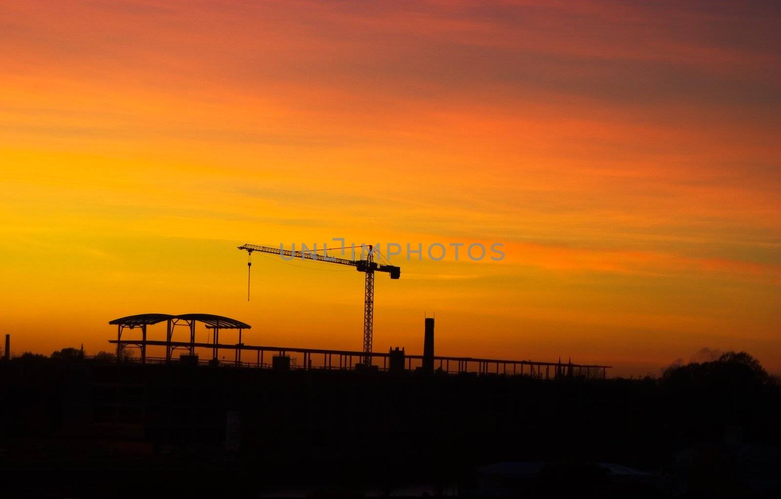 Tower crane in late evening over sunset skies