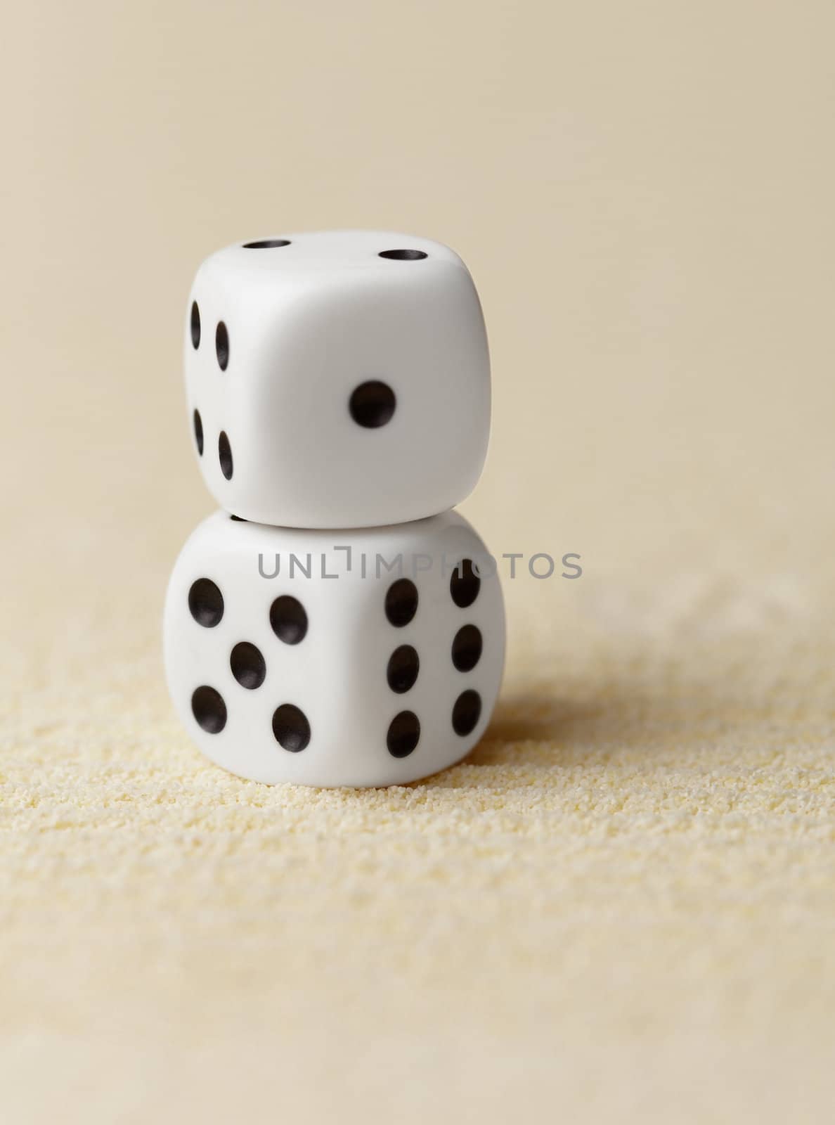 Two dice on the yellow sand - still life