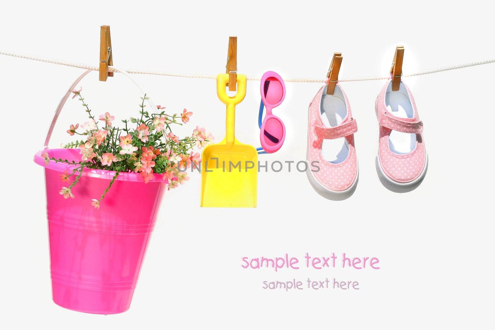 Pail,sunglasses and shoes for child on clothesline