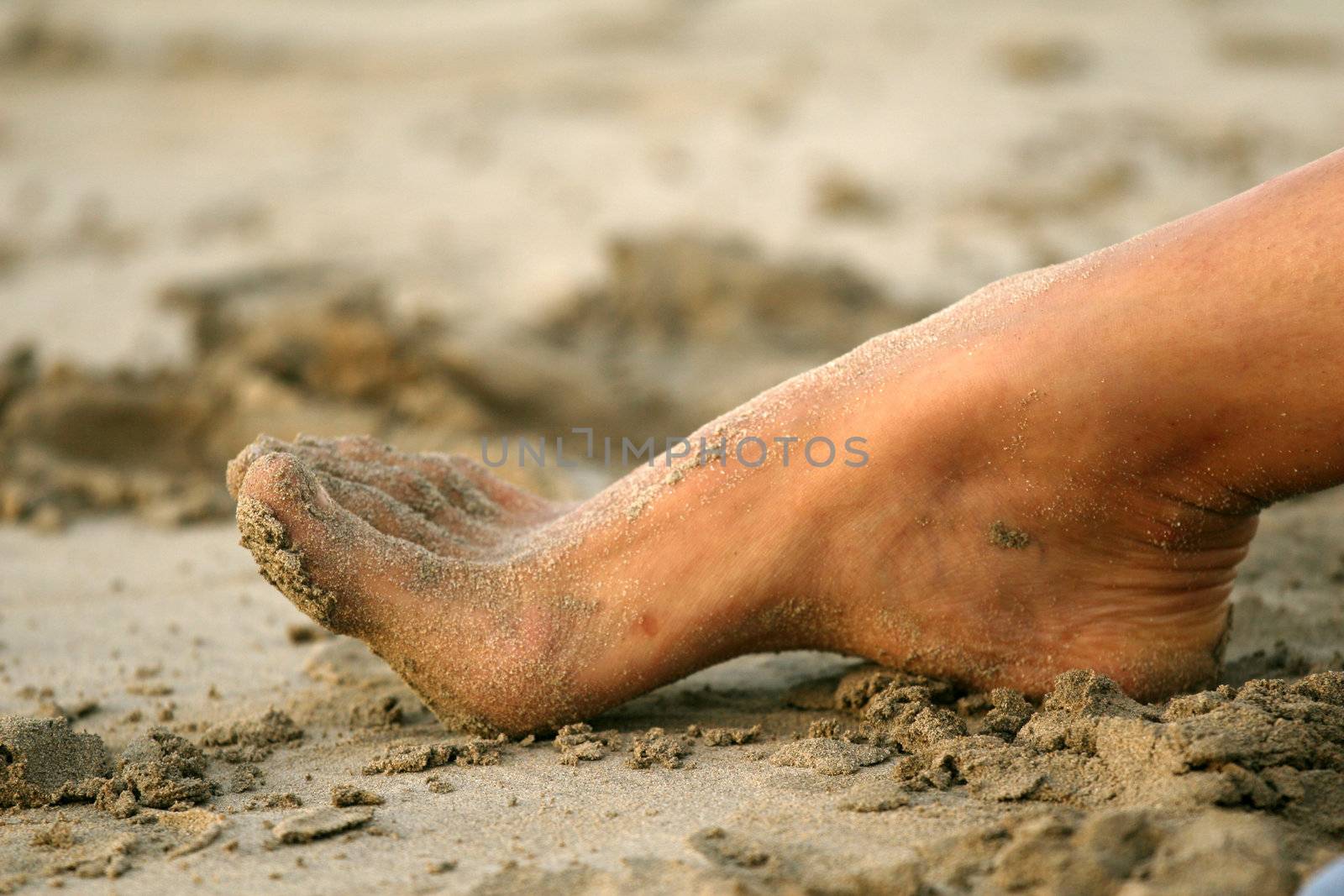 Foot in sand on the beach in caribbean
