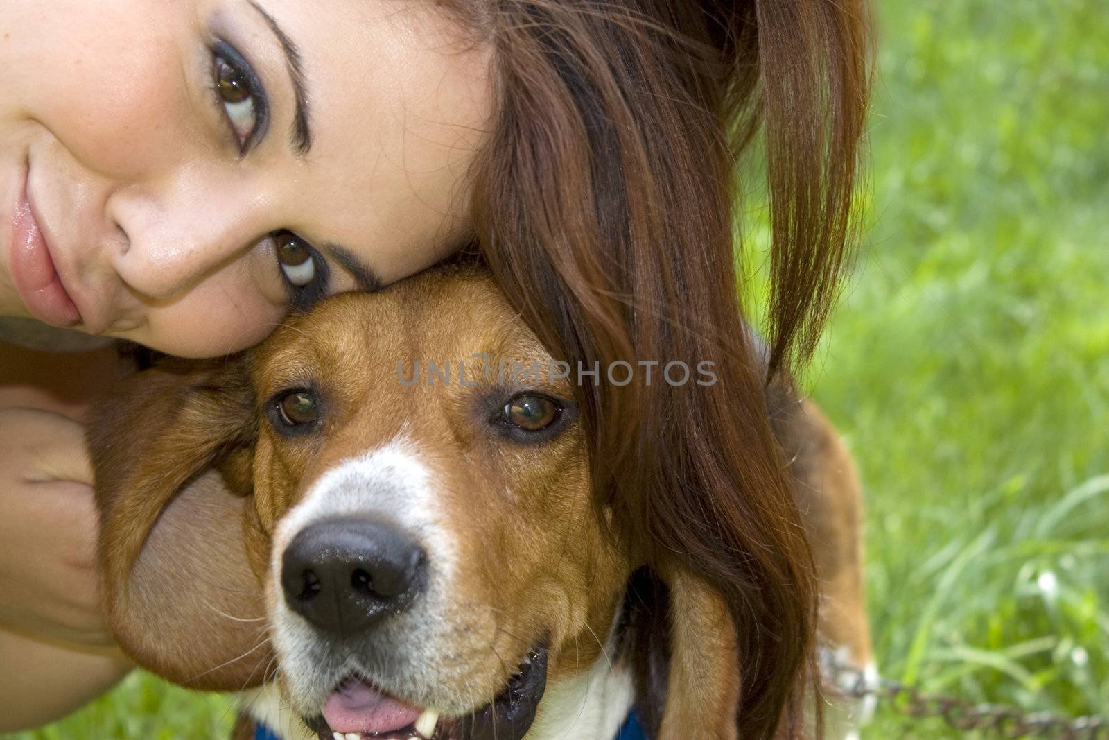 A pretty girl posing with her little beagle dog.