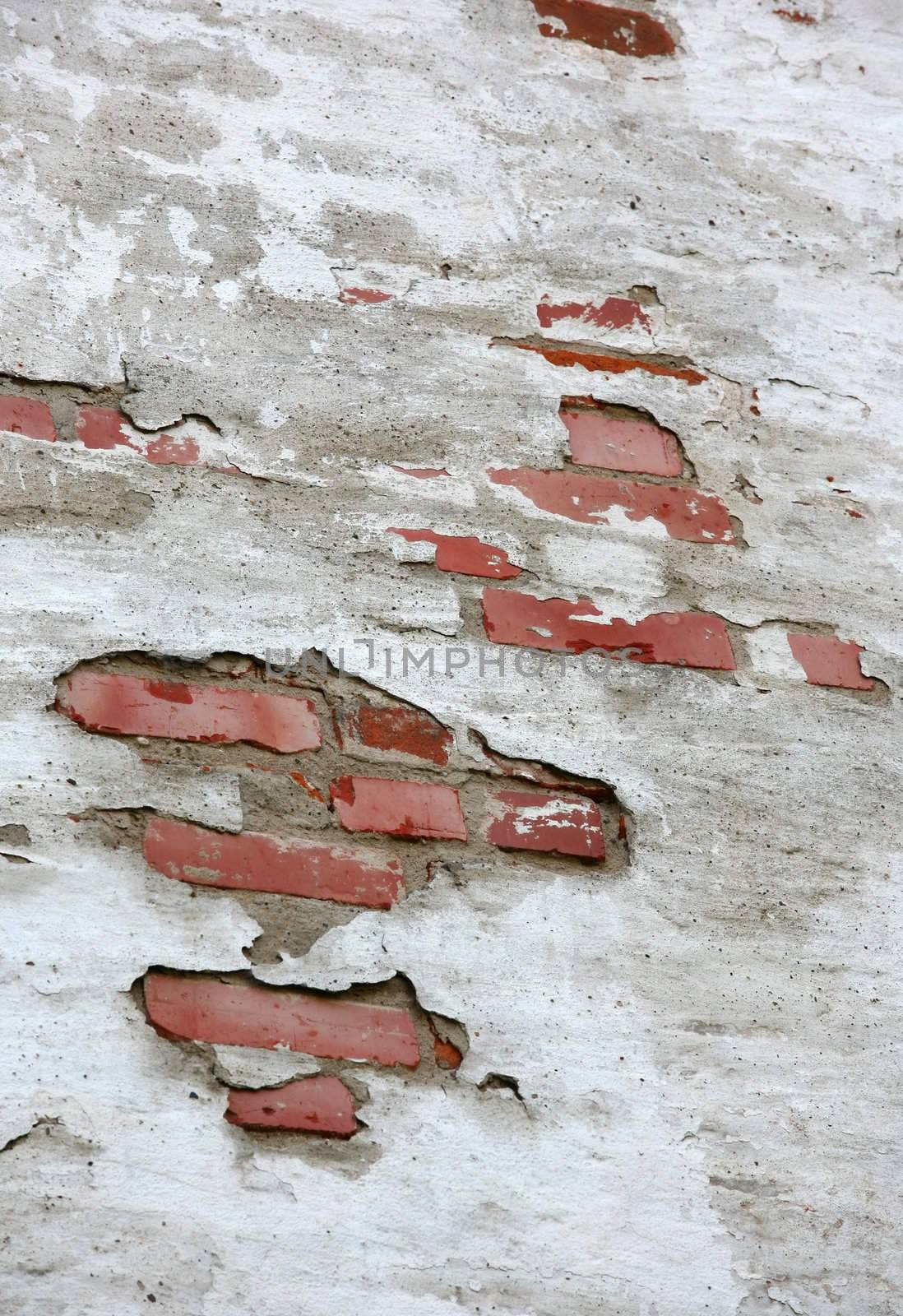 Fragment of old brick wall with white stucco