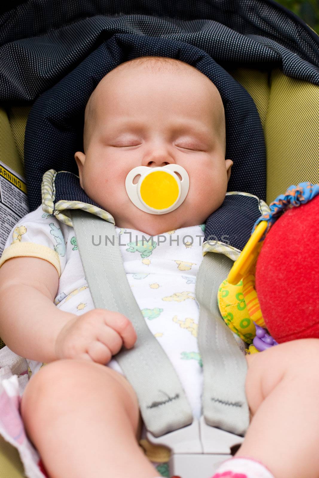 Baby sleeping in a car seat by naumoid