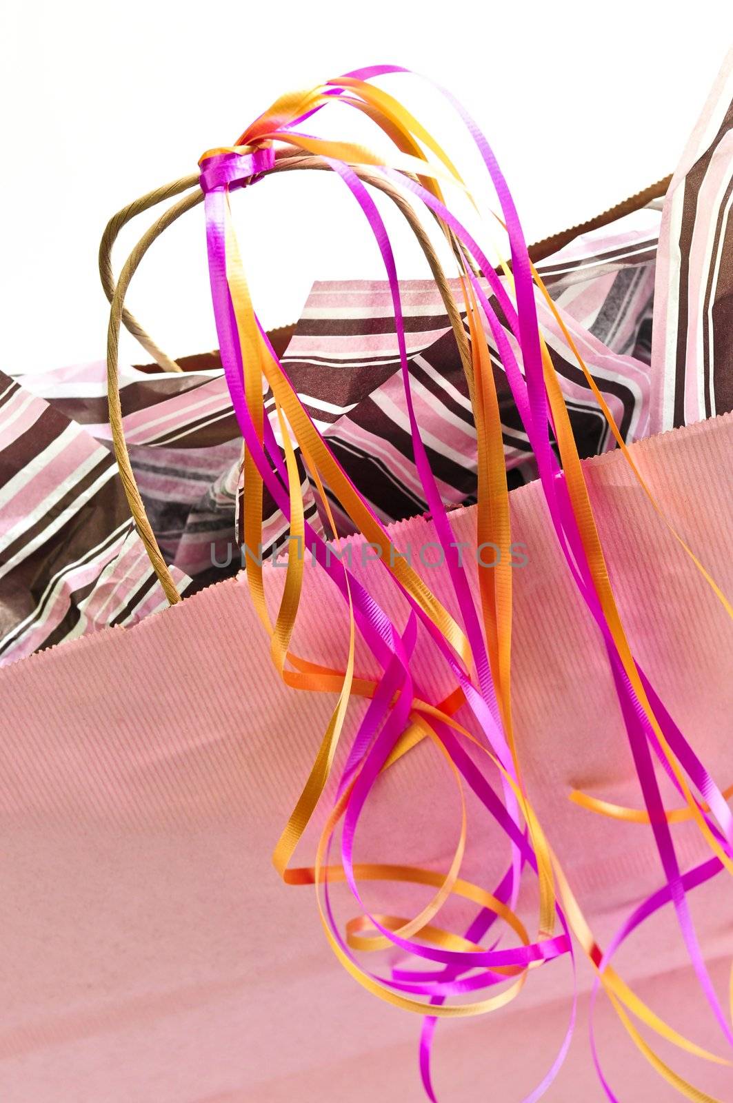 Pink shopping bag with ribbons isolated on white background