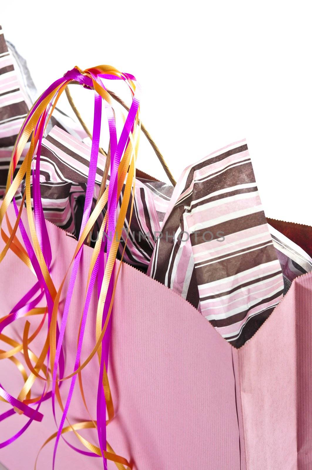 Pink shopping bag with ribbons isolated on white background