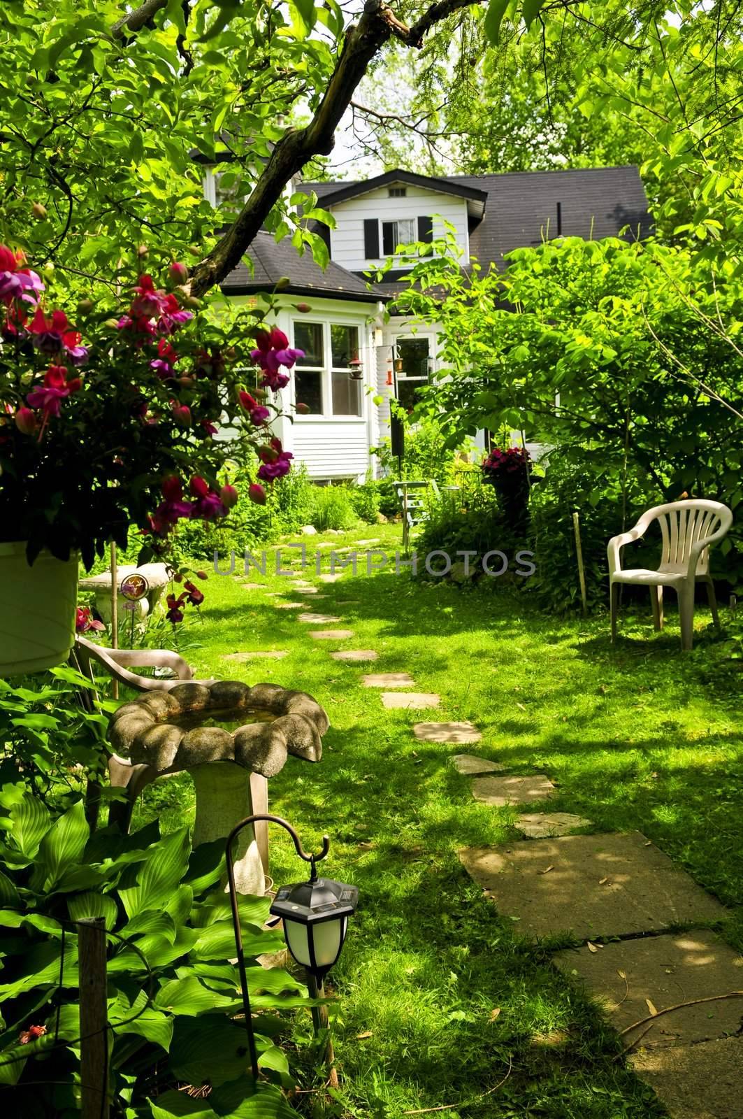 Path of steeping stones leading to a house in lush green garden