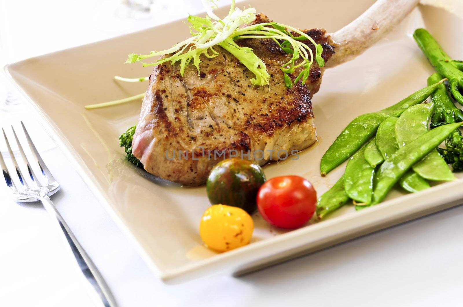 Gourmet dinner of veal rib chop and vegetables