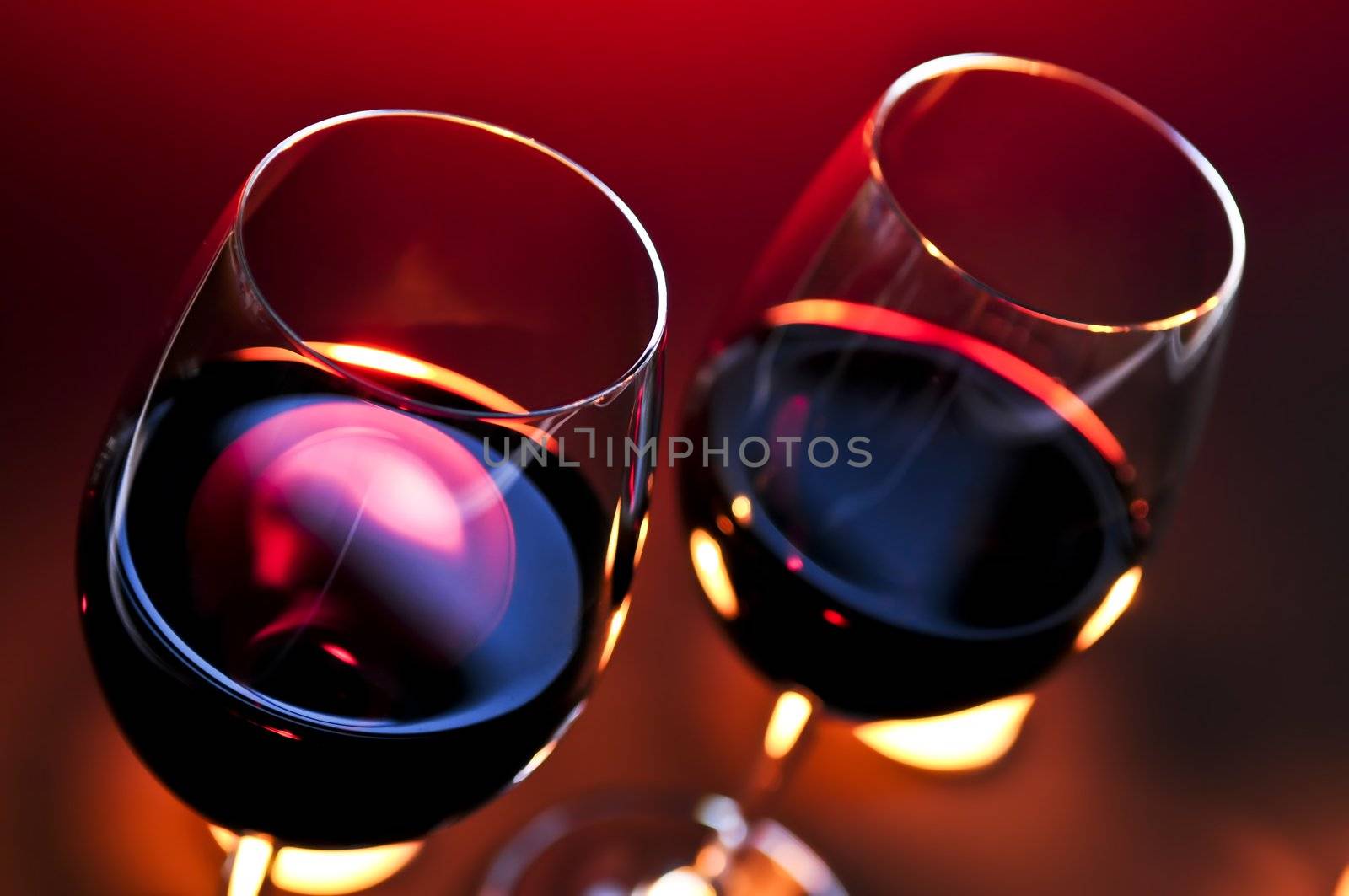 Two wineglasses with red wine at candlelight