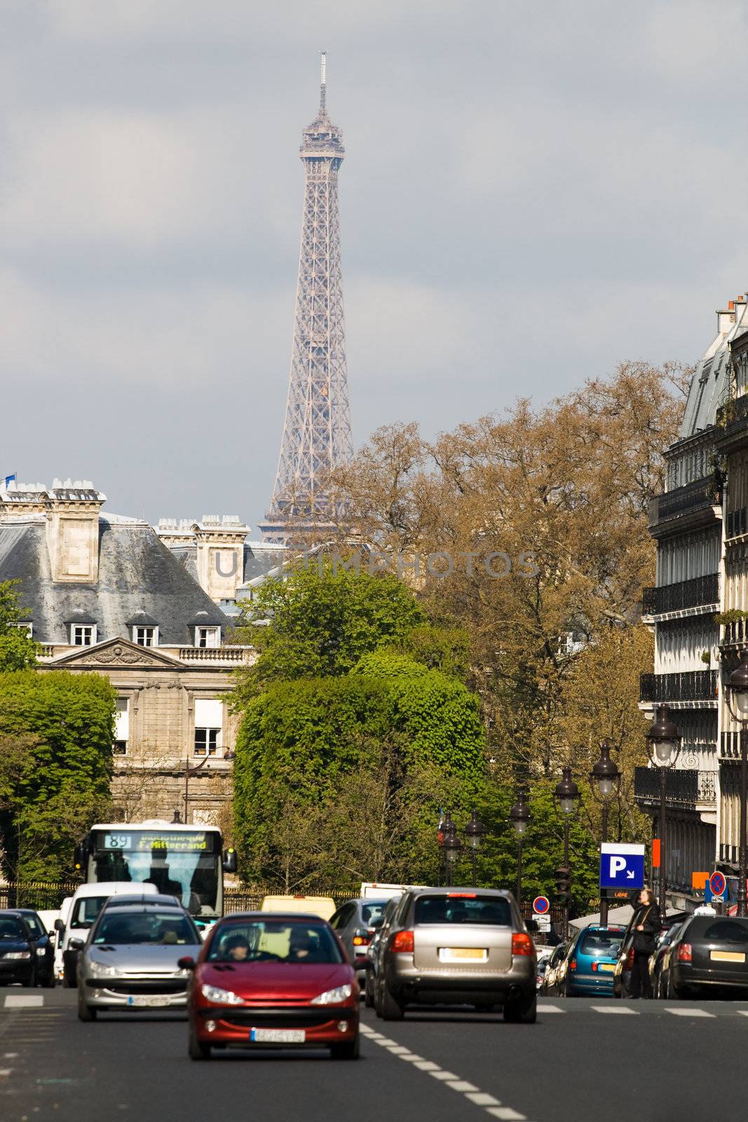 Street with cars in Paris, Latin quartal. Eiffel tower in background.