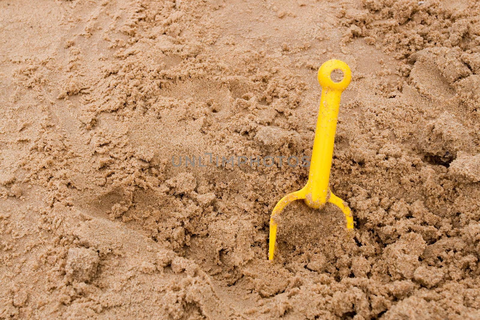 Forgoten yellow sand spade in sandy beach