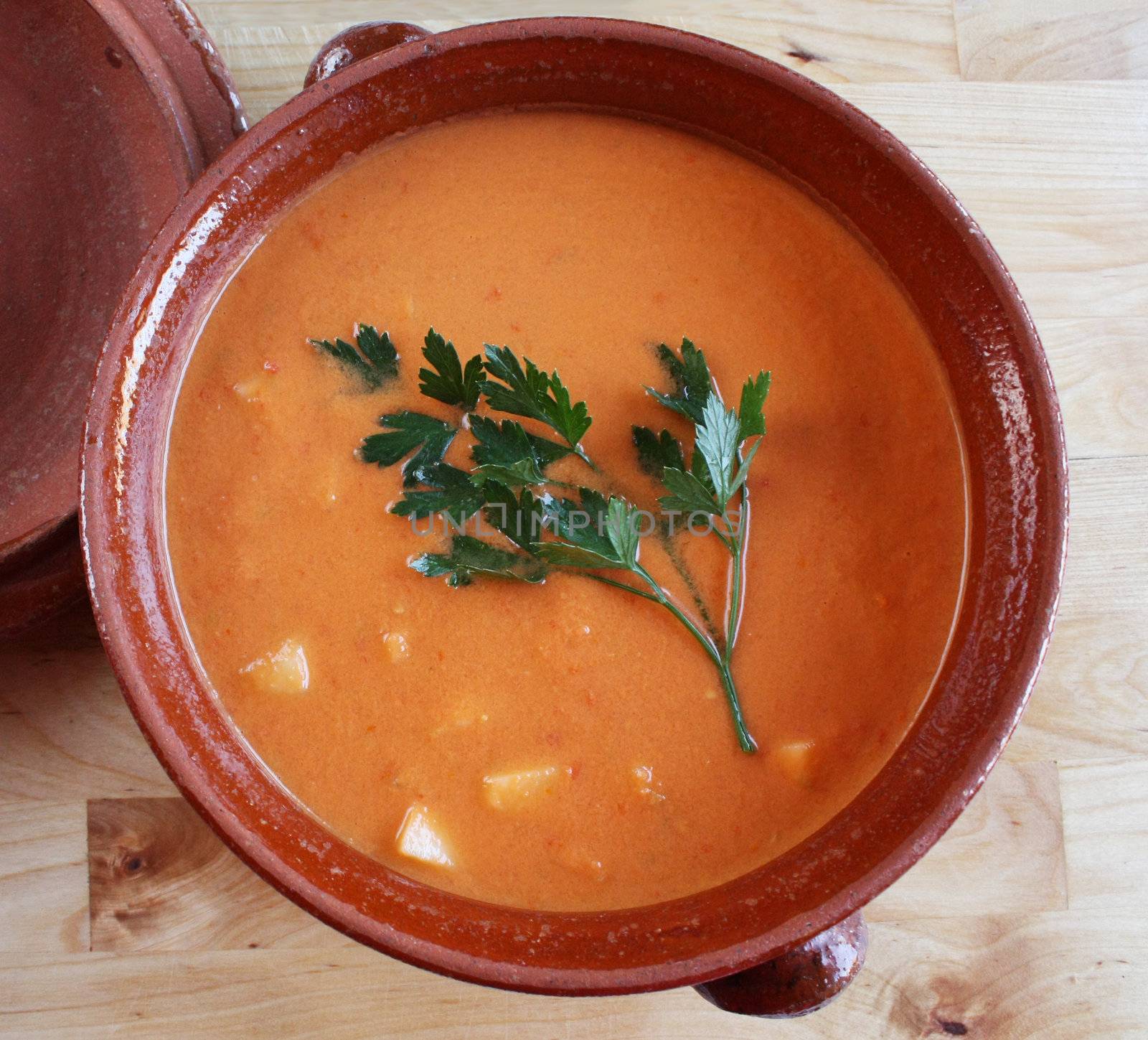 Andalusian gazpacho in a clay pot. It is a cold Spanish tomato-based raw vegetable soup and consumed during summer months due to its refresing qualities.