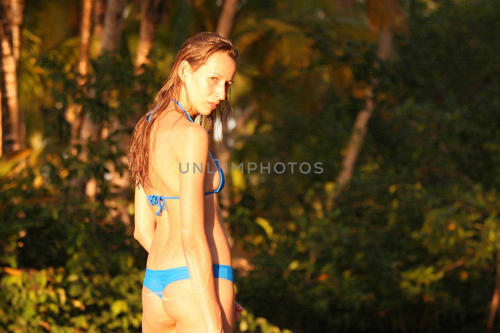 Jung woman posing on the beach near jungle