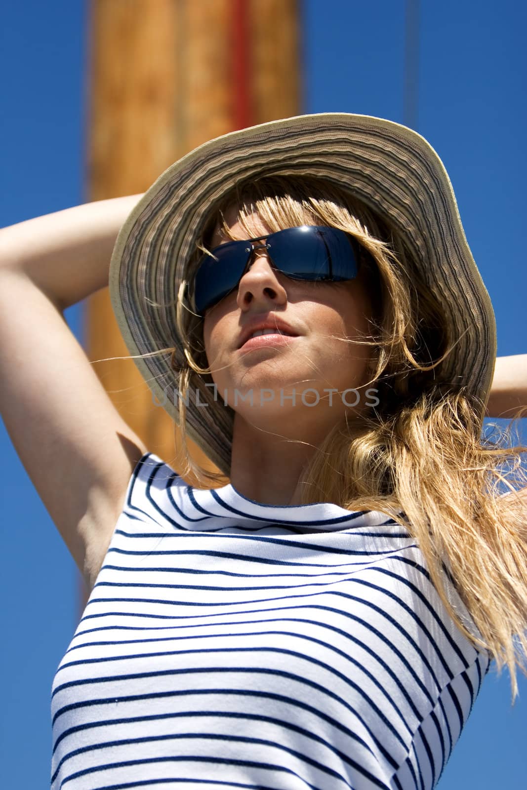 Beautiful young woman in sunglasses sailing on a boat