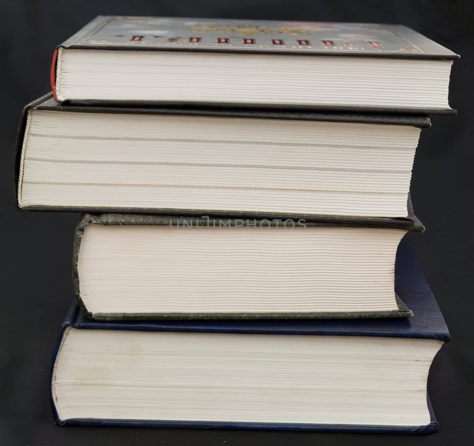 Some thick books on a black background