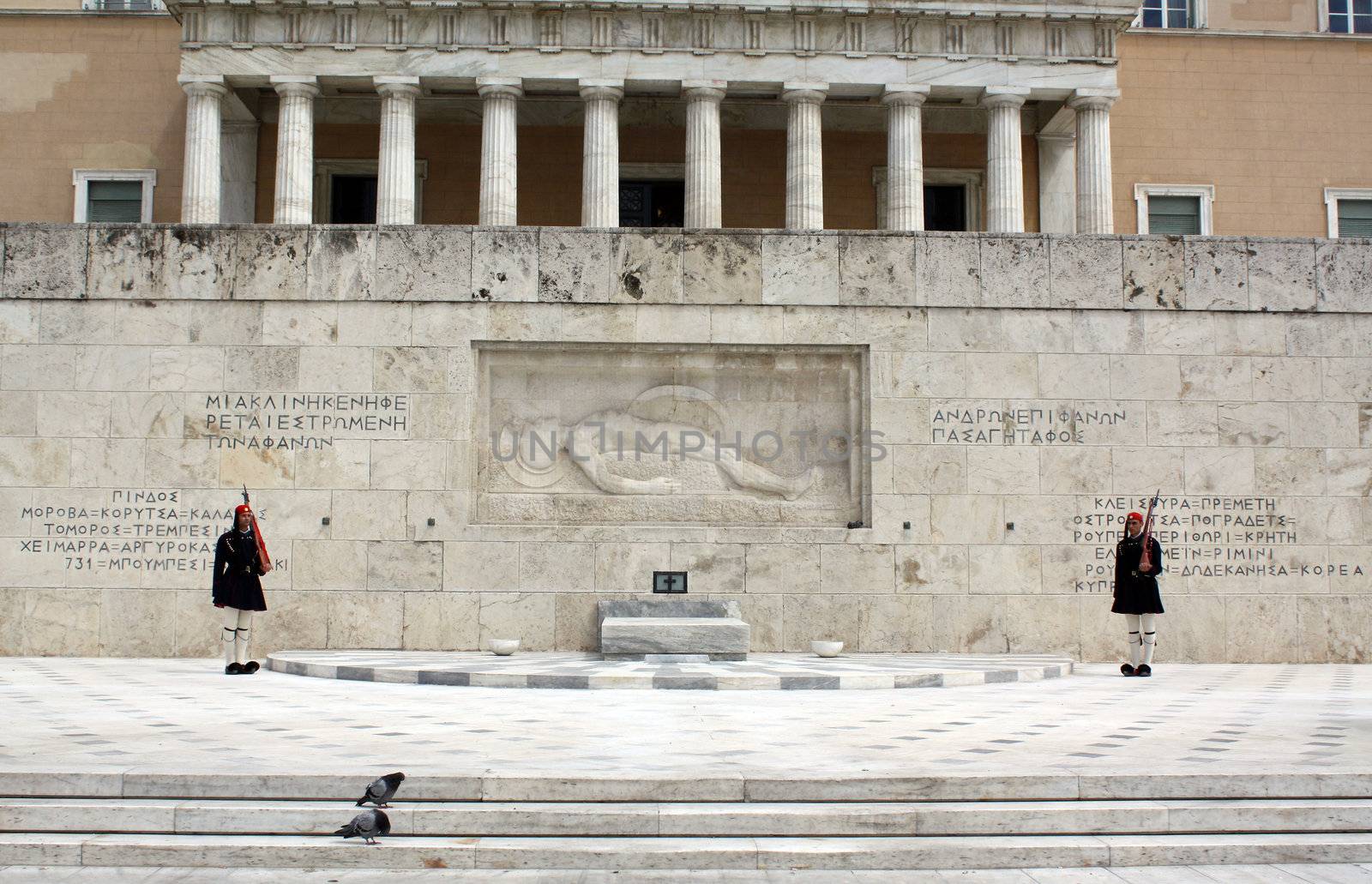 Athens, Greece - April 21, 2009: Evzones (presidential ceremonial guards) in front of the Unknown Soldier's Tomb at the Greek Parliament Building in Athens, opposite Syntagma Square. Evzones guard the Tomb of the Unknown Soldier, the Hellenic Parliament and the Presidential Mansion. They are also known locally as Tsoliades.