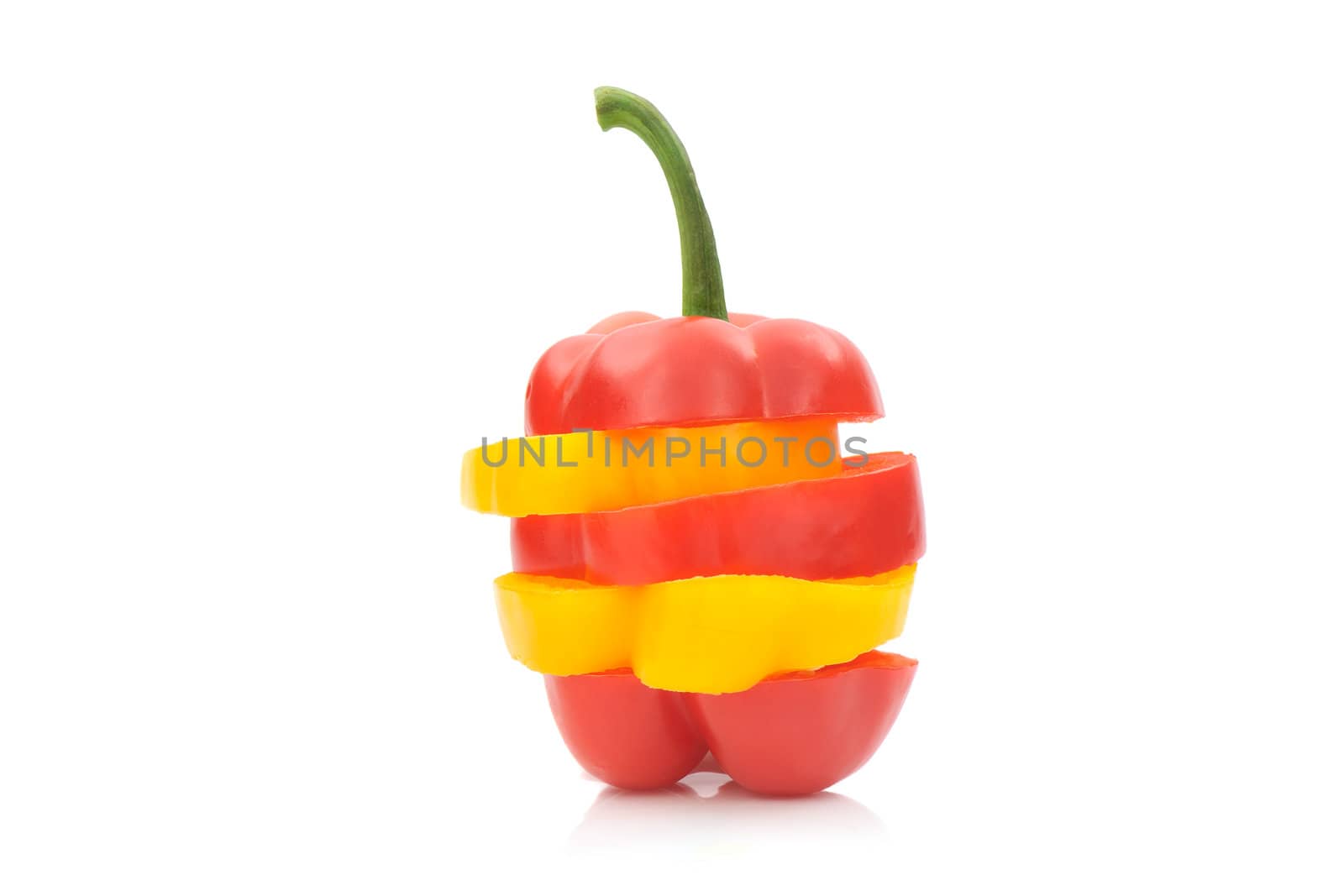 Piled yellow and red bell pepper slices on white background