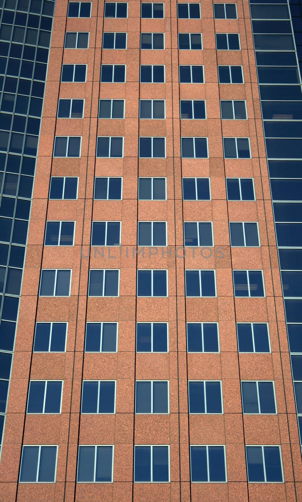 Windows of a terracotta-colored modern high-rise building.