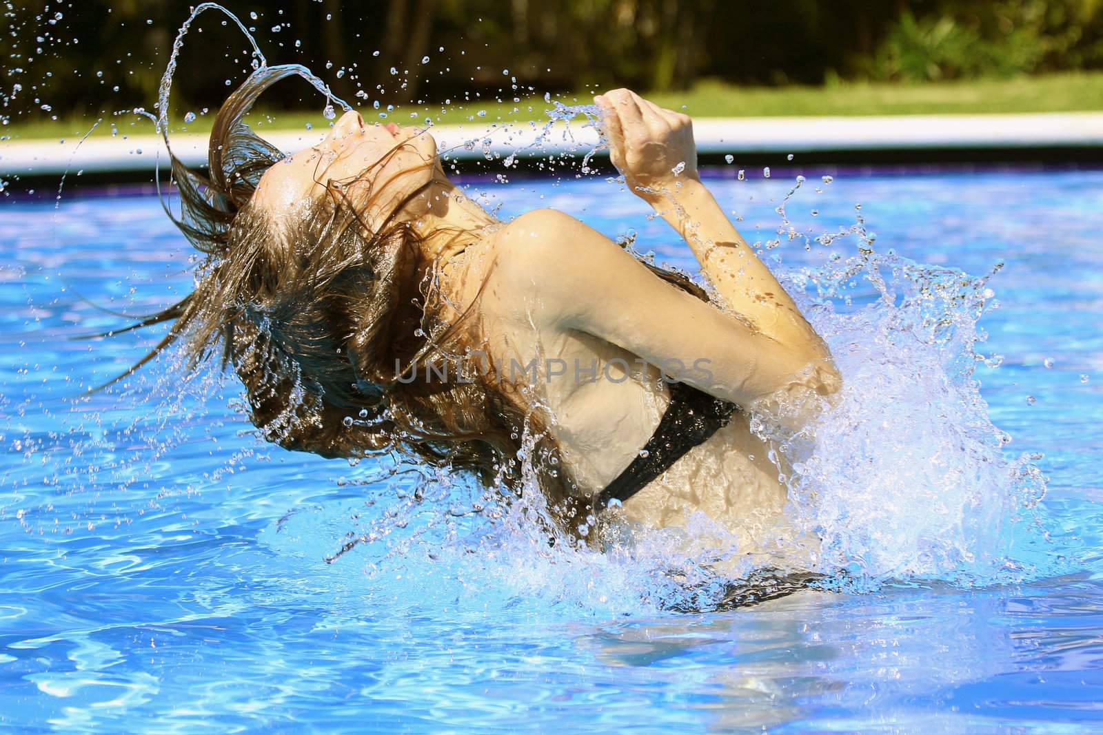 woman swinging her hair in the swimming pool