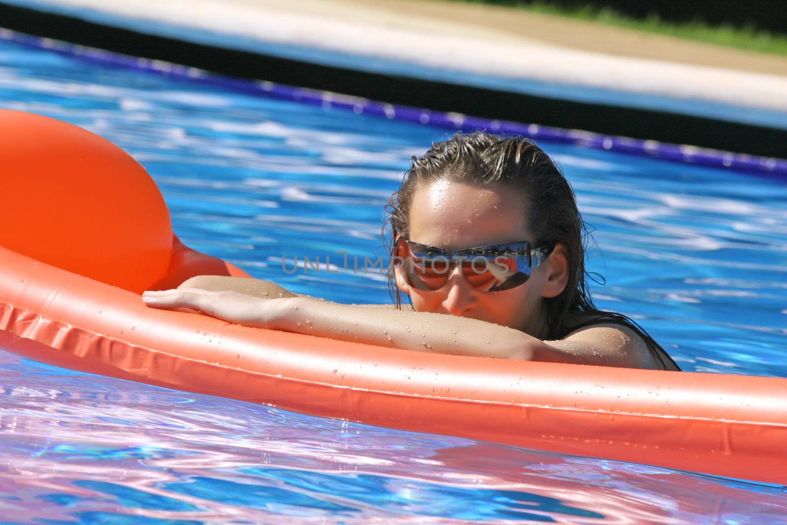 woman takes a sunbath in the swimming pool
