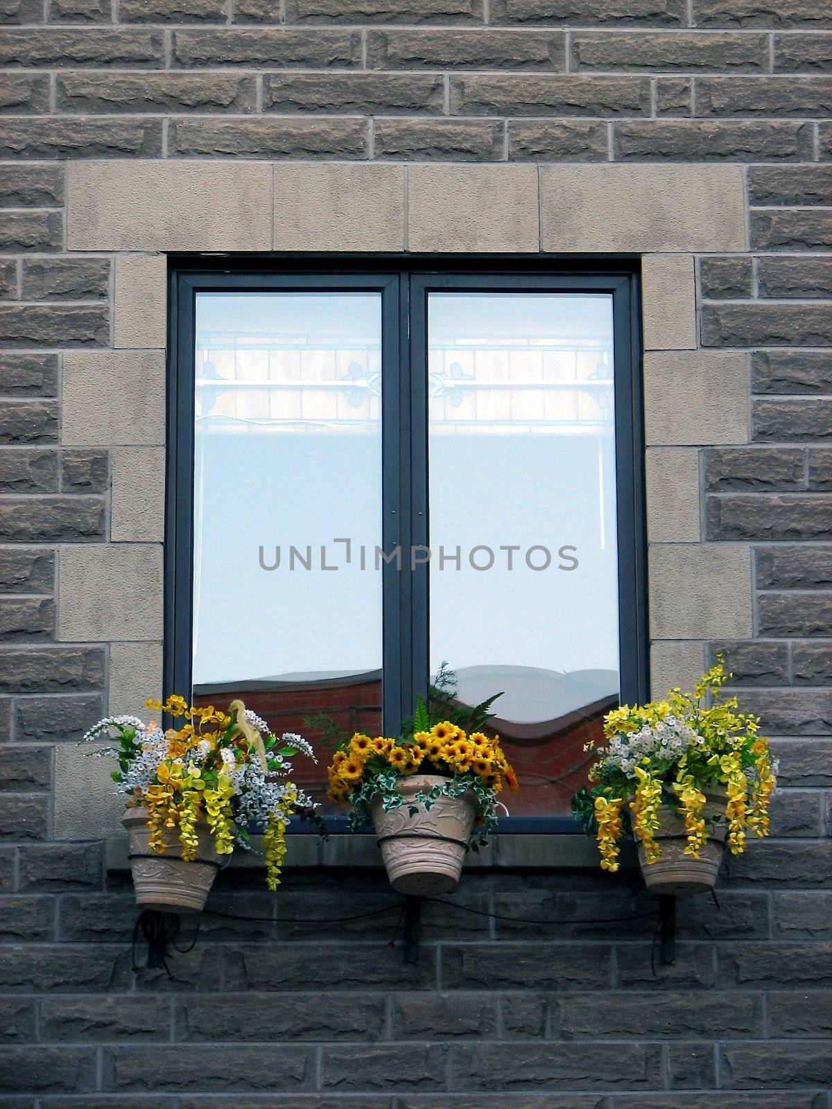 Window of an old stone house, decorated with flowers.