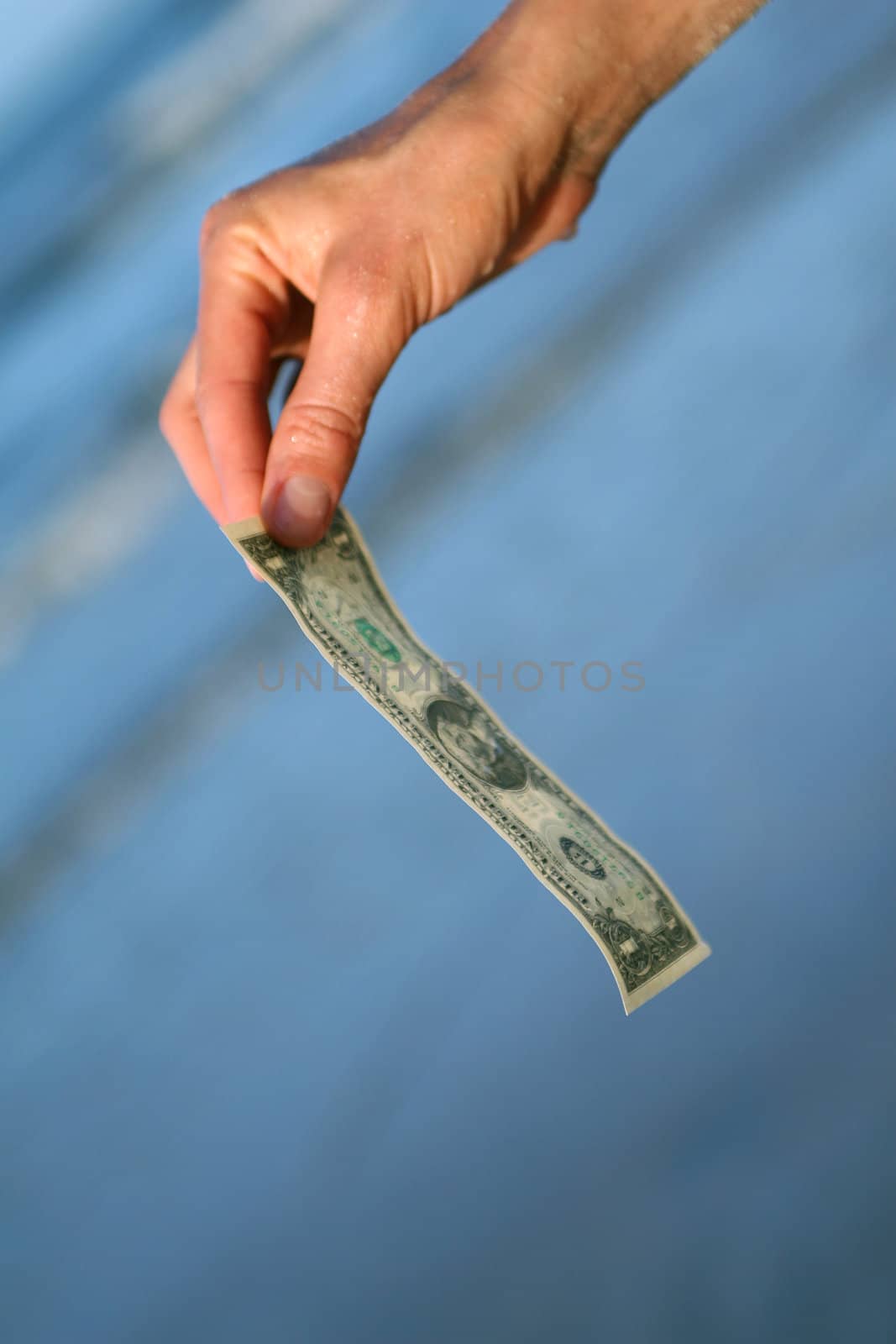 one dollar in the female hand on the beach