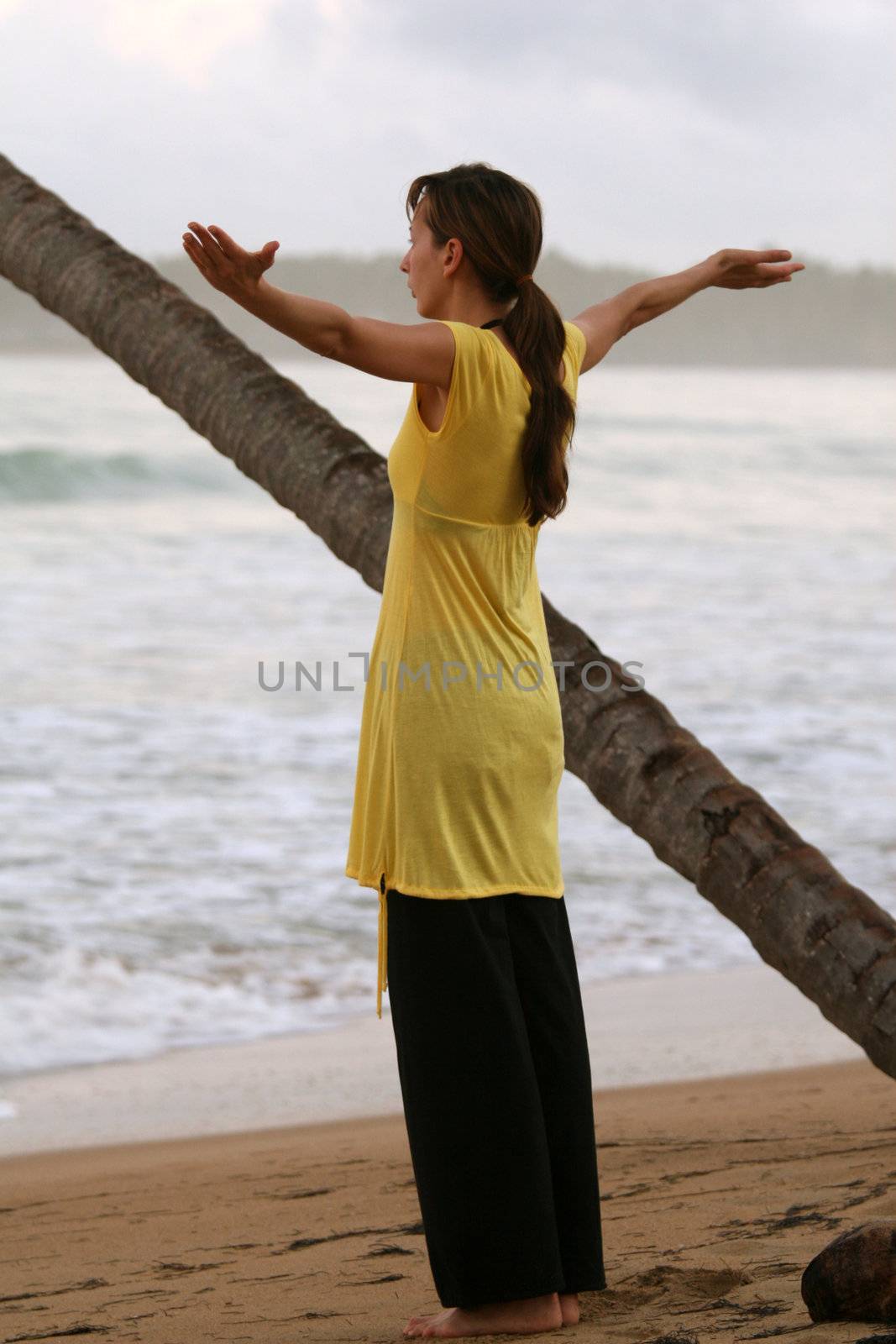breath exercise and yoga on the beach by sunset
